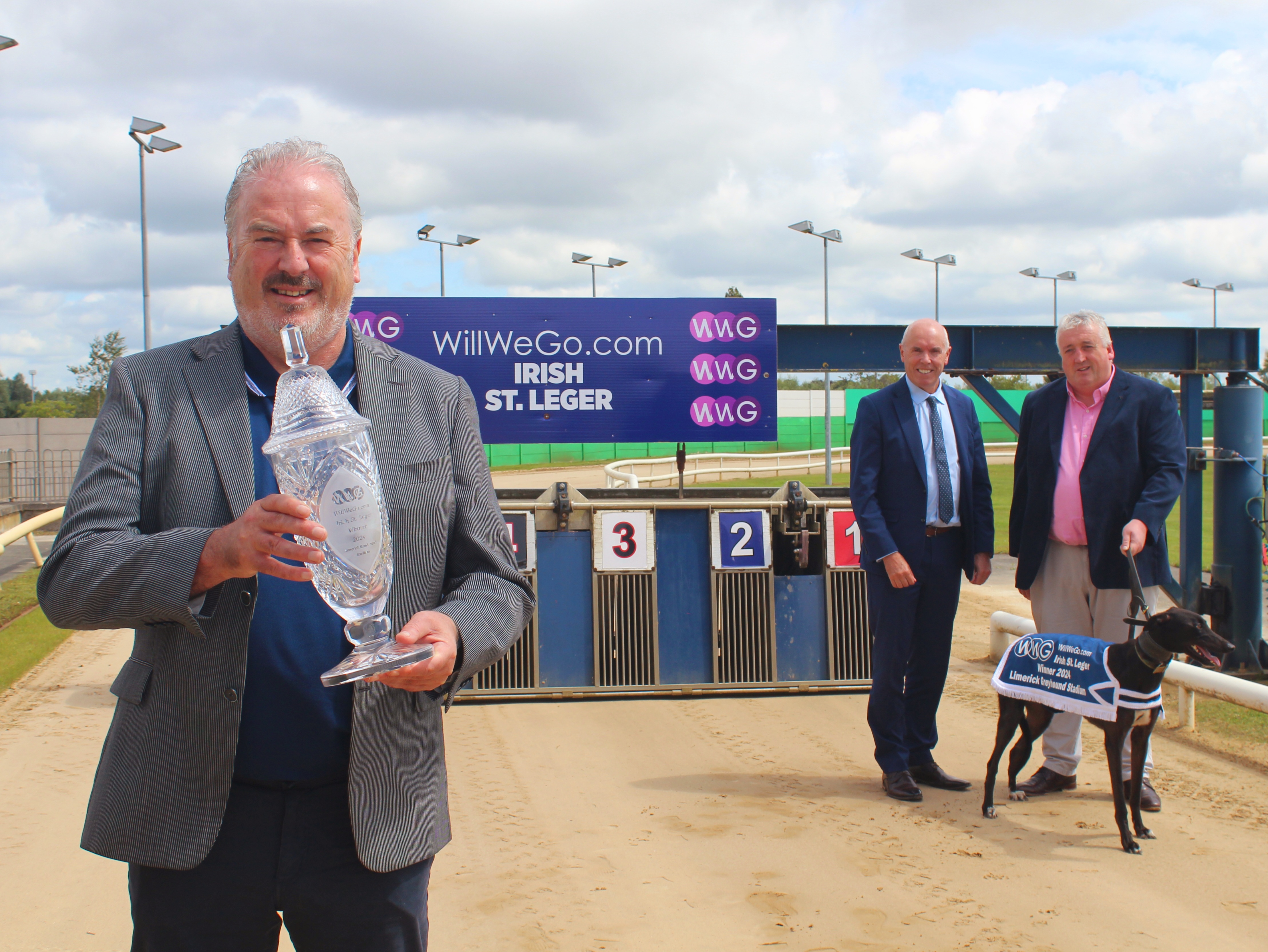 Ray Quinn, representing the sponsor, holding the trophy for this year’s WillWeGo.com Irish St. Leger at Limerick Greyhound Stadium with Tim Lucey, CEO of Greyhound Racing Ireland, and Jody Thompson, Racing Manager, with Sombra the greyhound.